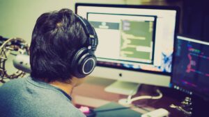 Jongen achter computer met koptelefoon
