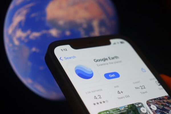 Hand,Holding,Iphone,Google,Earth,With,App.,Google,Earth,Is